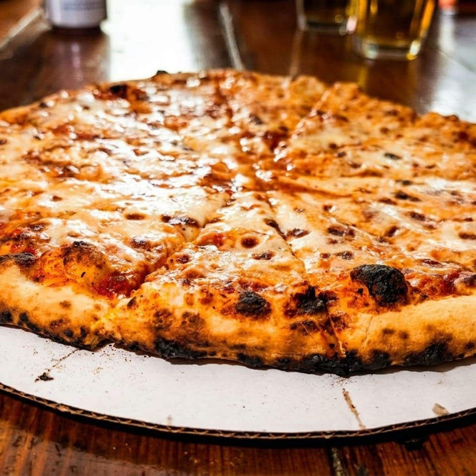 A large, sliced cheese pizza with a crispy, charred crust sits on a wooden table.